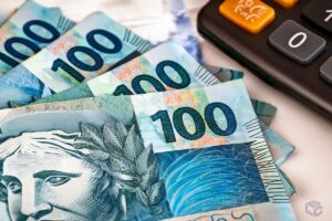 Notas de 100 reais com calculadora. Precatórios e RPV: atenção aos beneficiários.