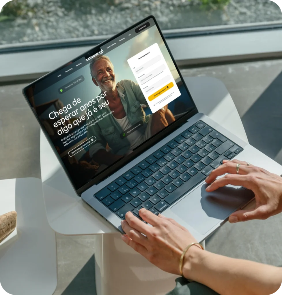 Laptop aberto exibindo site do LG Bank com homem sorridente e texto "Chega de esperar