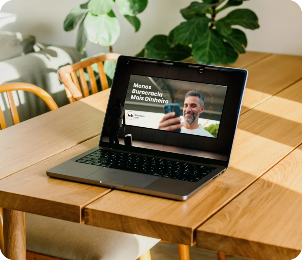 Laptop exibindo vídeo "Menos Burocracia Mais Dinheiro